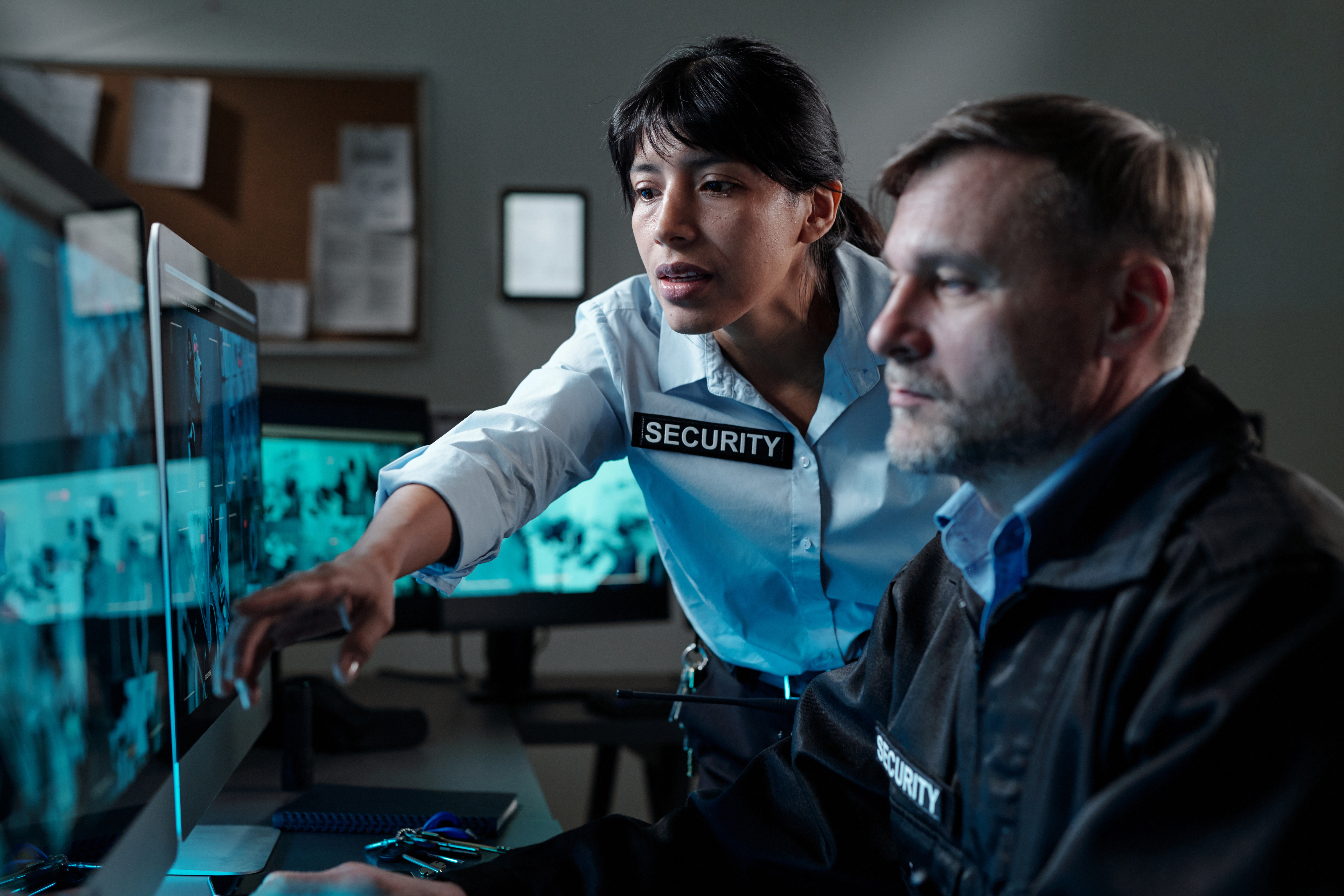 Security guards reviewing live CCTV footage on multiple monitors during a business security audit in Canada.